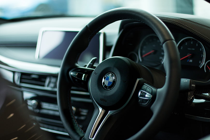 Close-up of BMW steering wheel and car interior dashboard
