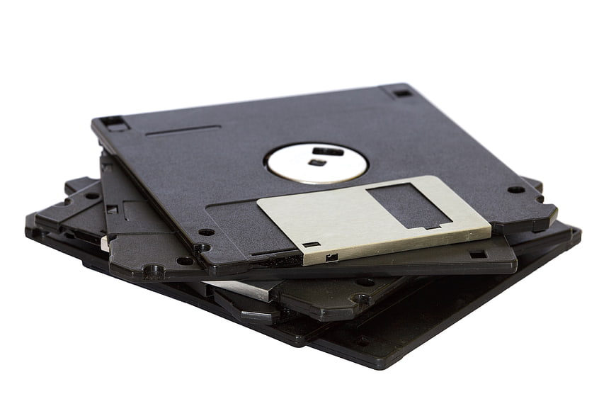 Stack of black 3.5-inch floppy disks on white background