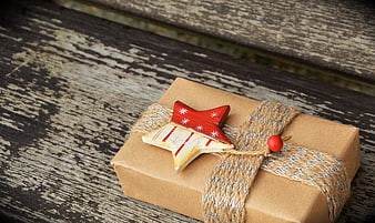 Rustic Christmas Gift Box with Wooden Star on Weathered Wood