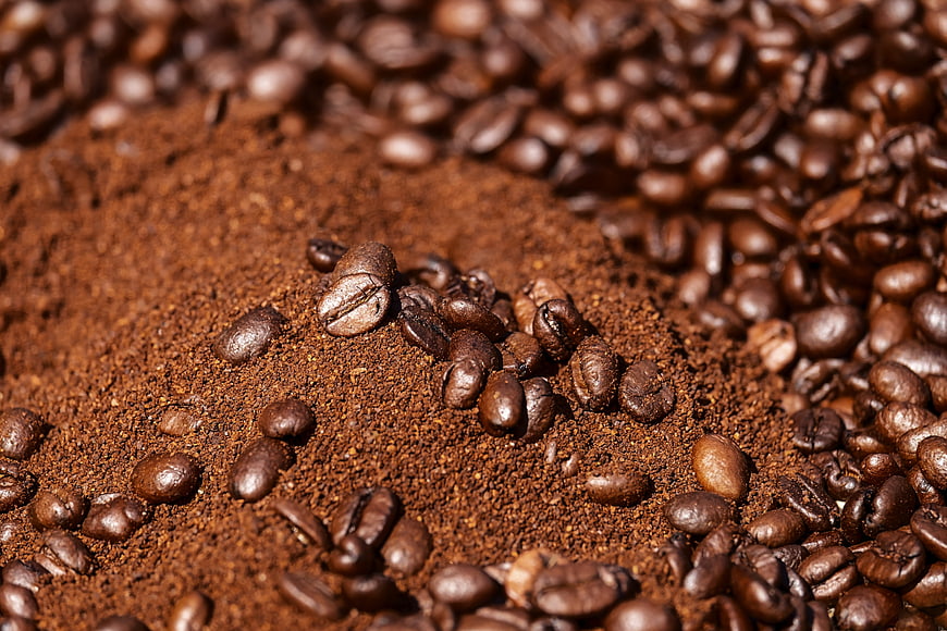 Close-up of roasted coffee beans and ground coffee powder