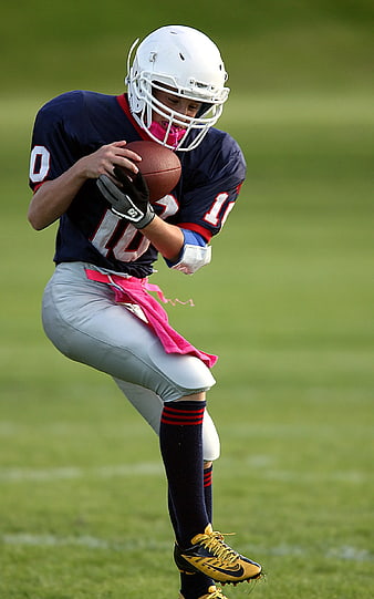 Female Football Player Running with Ball on Field