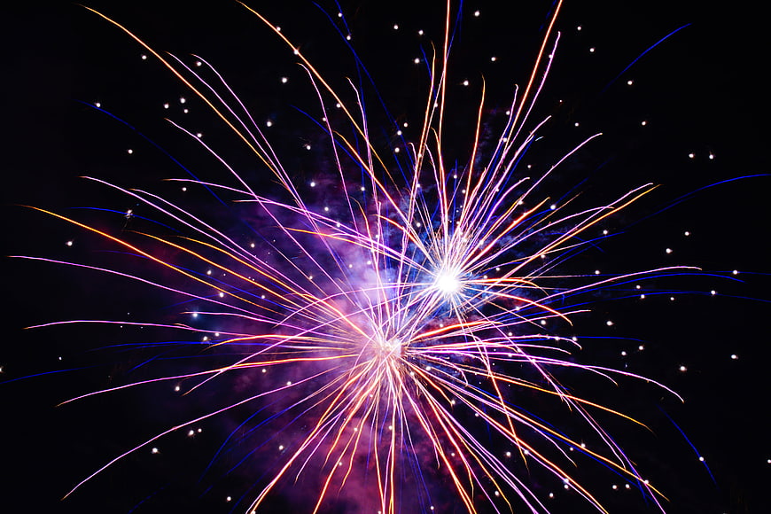 Vibrant multicolored fireworks exploding in night sky