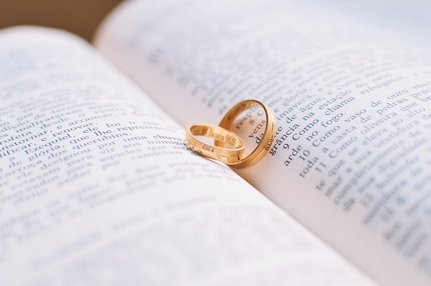 Gold wedding rings on open bible page