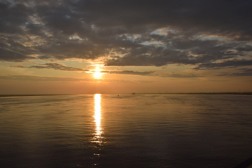 Golden Sunset Over Calm Sea with Cloudy Sky