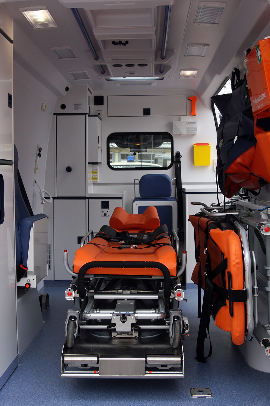 Interior of modern ambulance with orange stretcher and medical equipment
