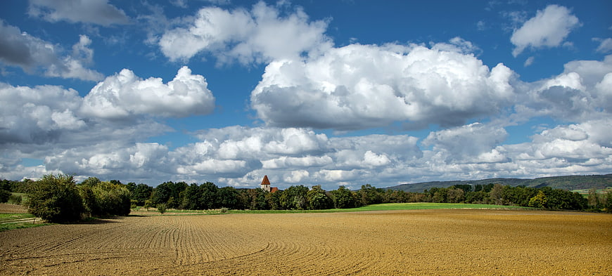 Panoramic rural landscape with golden field and dramatic clouds