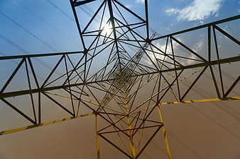 Low angle view of high voltage electricity pylon against blue sky