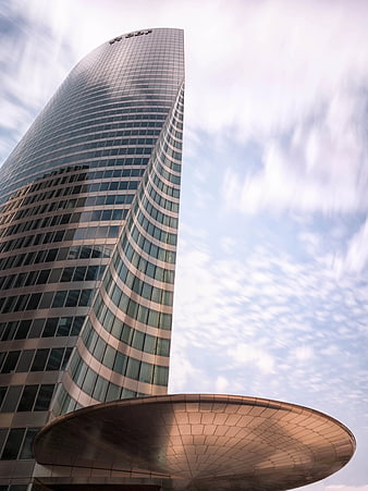 Low angle view of modern glass skyscraper with curved architecture