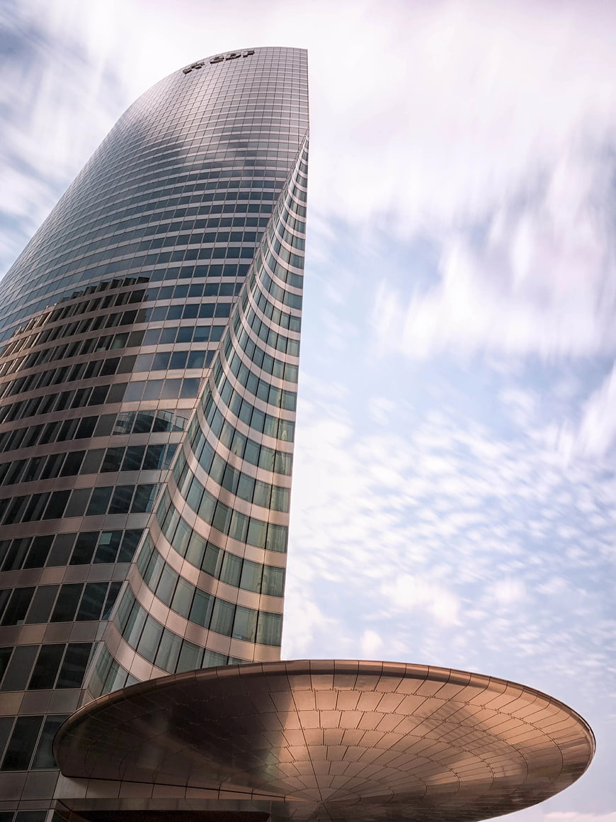 Low angle view of modern glass skyscraper with curved architecture
