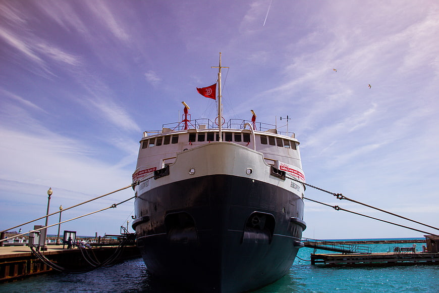 Front view of large ferry docked at pier with blue sky