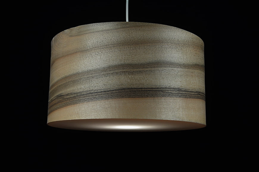 Modern wooden pendant lamp with warm light on black background