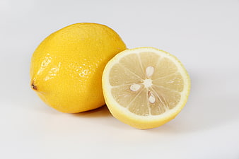 Fresh whole and sliced lemon on white background