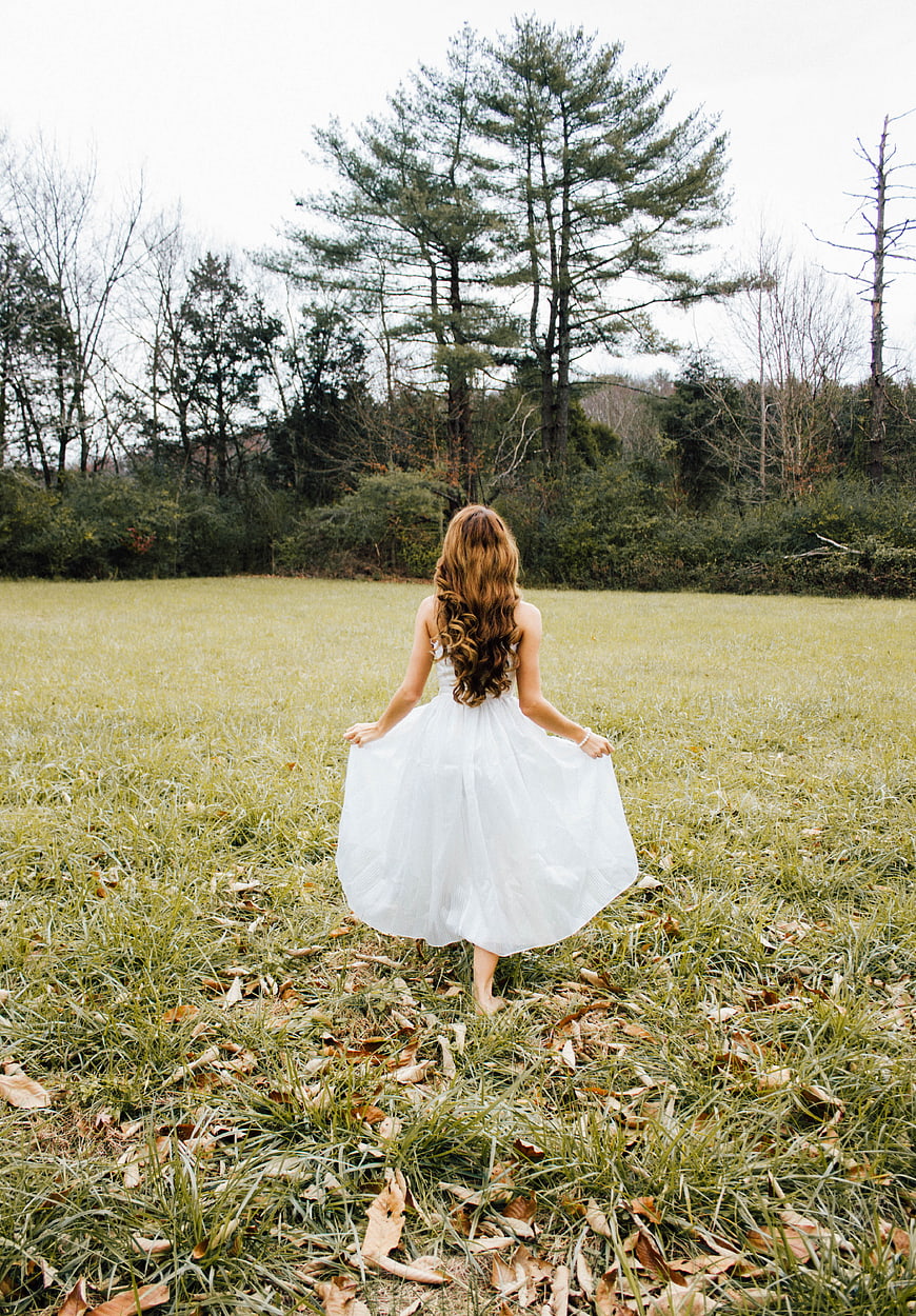 Woman in White Dress Walking Away in Grassy Field
