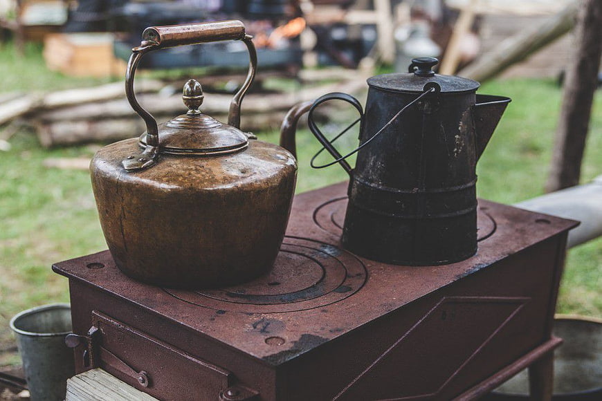 Vintage Kettle and Coffee Pot on Rustic Wood Stove