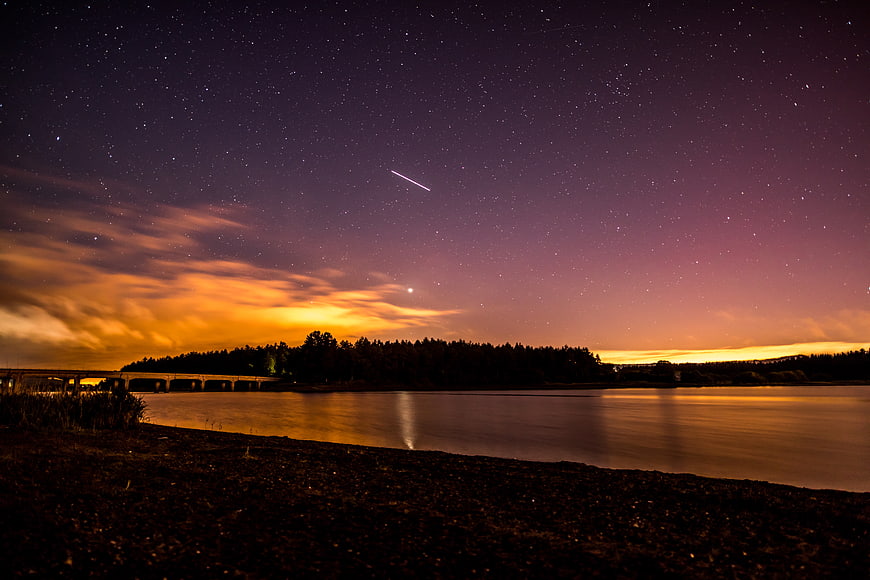 Night Sky Meteor Over River with Starry Sky and Bridge