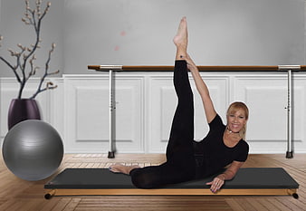 Woman performing Pilates leg lift exercise on reformer
