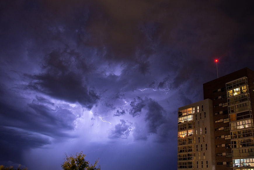 Dramatic Lightning Storm Over Modern City Apartment Buildings at Night