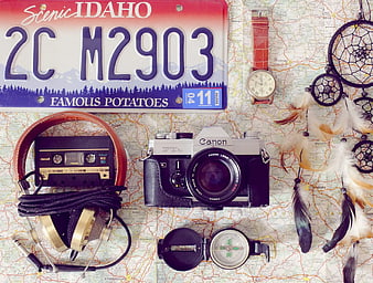 Vintage travel accessories and camera on map background