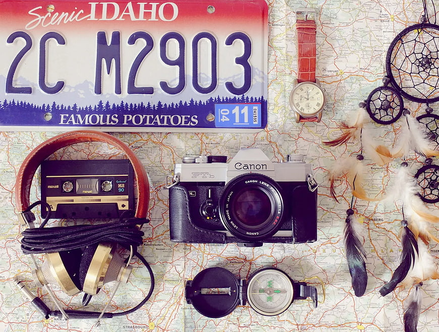 Vintage travel accessories and camera on map background
