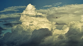 Vintage Biplane Flying Through Dramatic Clouds
