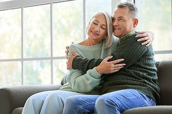 Happy Senior Couple Hugging on Sofa at Home