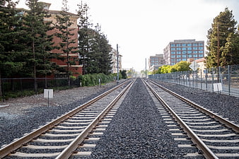 Parallel Railroad Tracks Leading Through Urban Cityscape