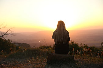 Woman Watching Golden Sunset Over Hazy Mountain Valley