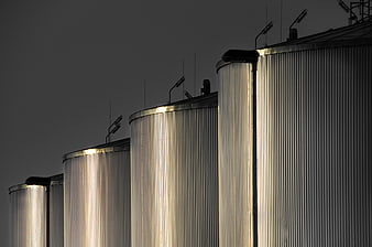 Industrial metal silos with vertical lighting at night