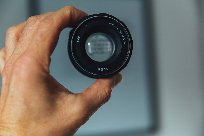 Hand holding vintage Helios 44M camera lens close-up
