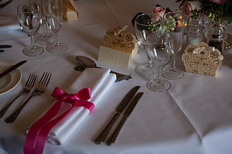Elegant wedding table setting with pink ribbon and lace favor