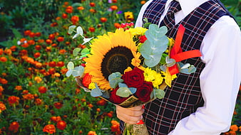 Man in Plaid Vest Holding Sunflower Bouquet in Garden