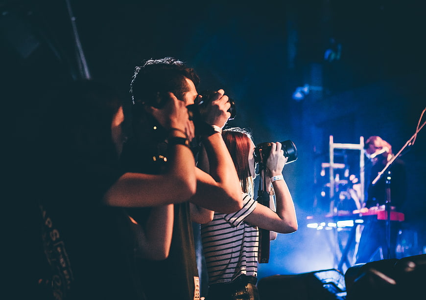 Photographers capturing a live concert performance with cameras