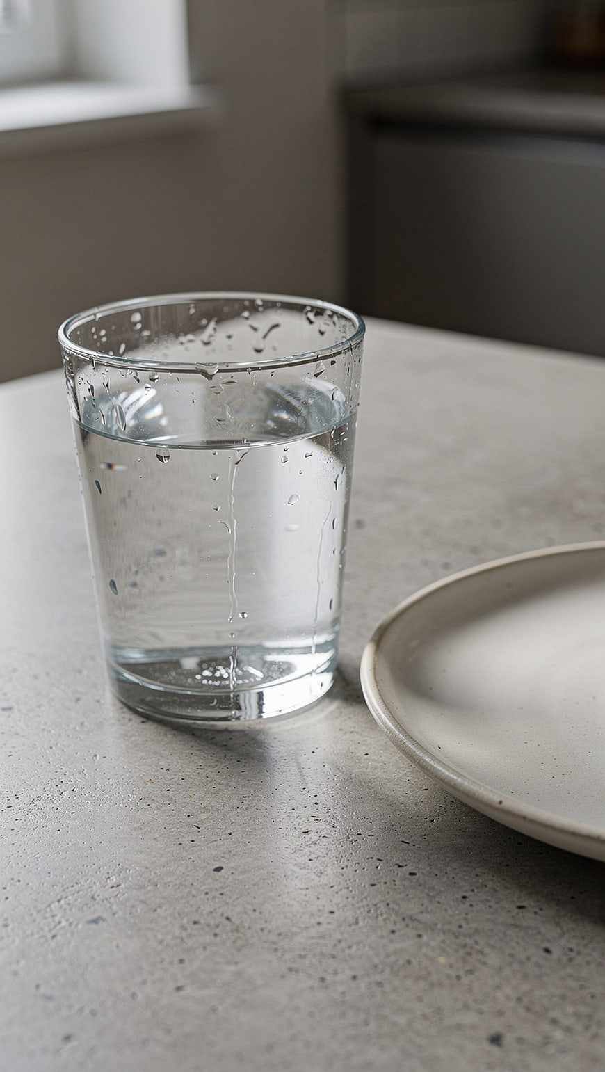 Condensation on a Glass of Water on a Concrete Table