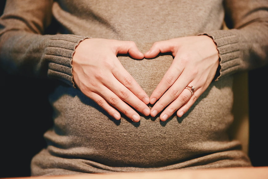 Pregnant Woman Making Heart Shape With Hands On Belly