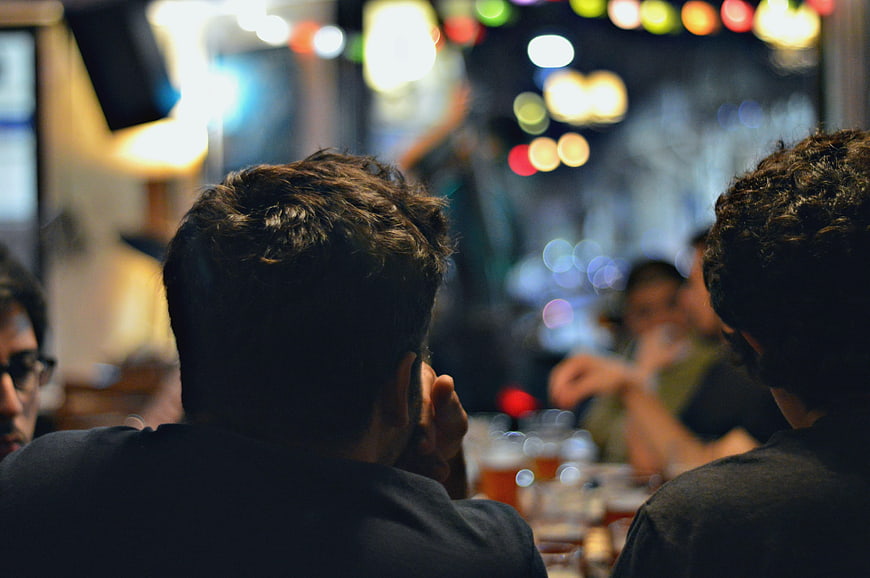 Back view of men watching live music in a bar
