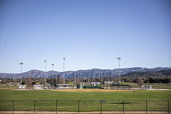 Empty baseball field with mountains and blue sky background