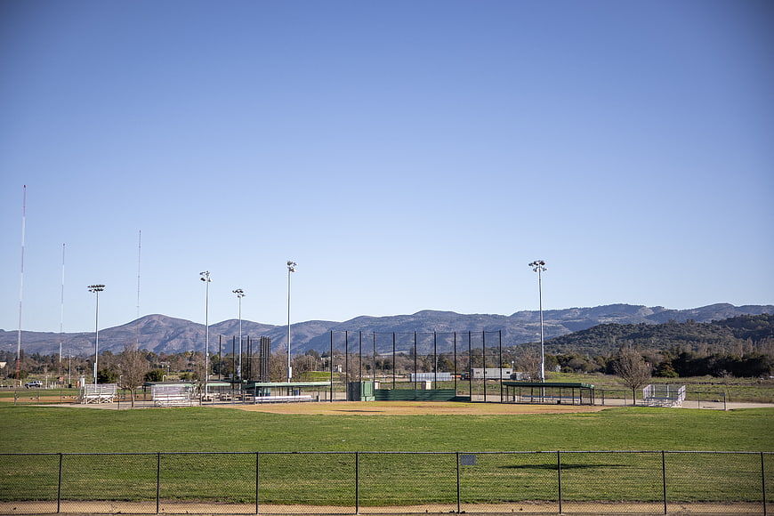 Empty baseball field with mountains and blue sky background