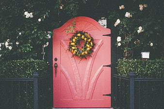 Pink arched door with lemon wreath and white roses