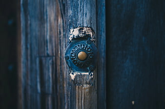 Close-up of vintage ornate door knocker on weathered blue wood