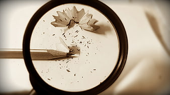 Magnifying glass over pencil shavings and graphite dust