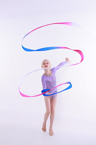 Young rhythmic gymnast performing with a colorful ribbon