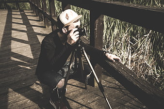Photographer with Camera and Tripod on Wooden Boardwalk