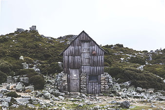Weathered wooden cabin on rocky mountain landscape