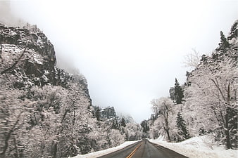 Snowy Mountain Road Winding Through Foggy Canyon