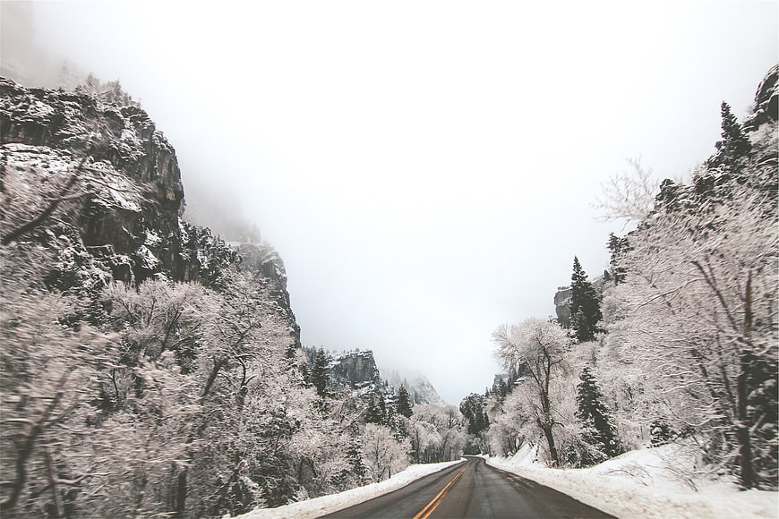 Snowy Mountain Road Winding Through Foggy Canyon