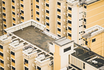Aerial view of yellow apartment buildings with rooftop details