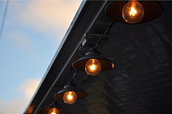 Vintage Edison Bulbs Hanging Under Awning at Dusk