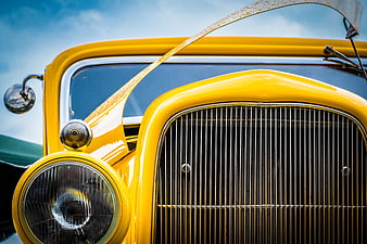Close-up of Vintage Yellow Car Grille and Headlight