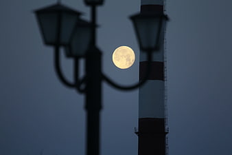Full Moon Behind Blurred Street Lamp and Tower