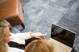 Overhead view of businesswoman pointing at laptop screen